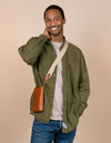 Charlie phone bag - cognac classic leather - male model product image with organic cotton webbing strap