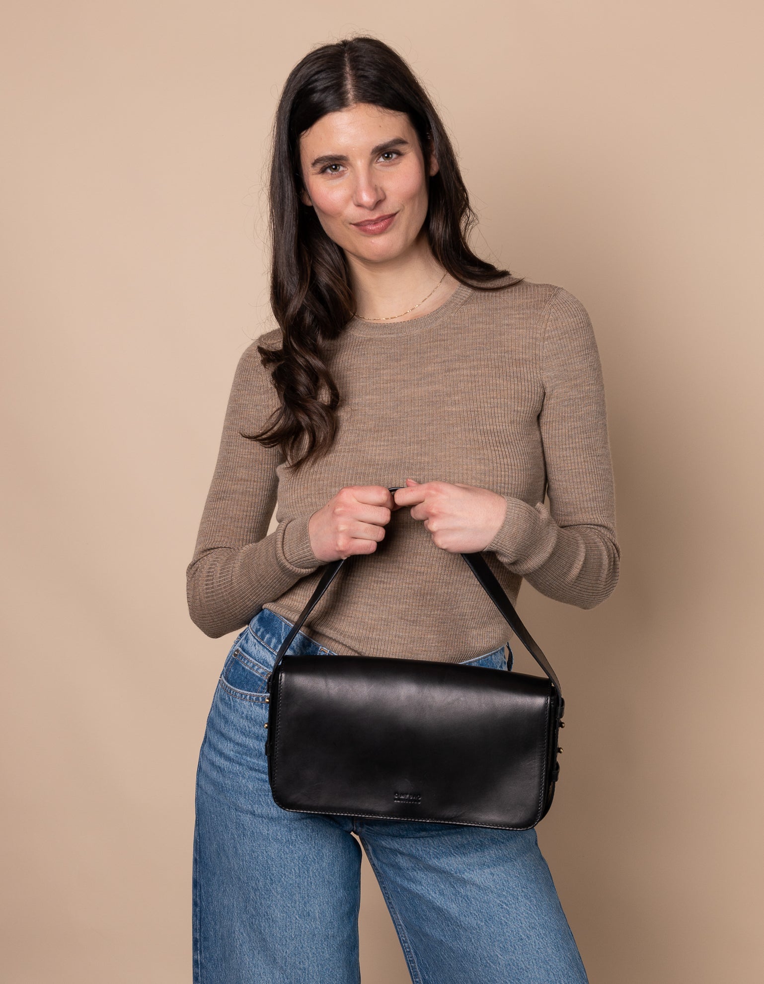 Black Baguette Leather womens handbag. Square shape with an adjustable strap. Model image