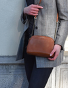 Cognac Leather womens handbag. Square shape with an adjustable leather & chain strap. Lifestyle image.