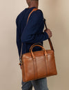 Harvey in cognac classic leather, male model product image with adjustable strap.