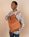 Jean Backpack in Wild Oak Soft Grain. Leather - Male model image - Unzipping the bag