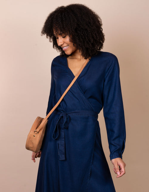 Luna Bag Camel Hunter Leather. Circular crossbody bag for women. female model image.