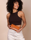 Pau Pouch Cognac Leather purse. Rectangular shaped fold over wallet. Female model image