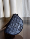 Laura Purse Black Classic Croco Leather. Round mood shape coin purse unisex wallet. Lifestyle image.