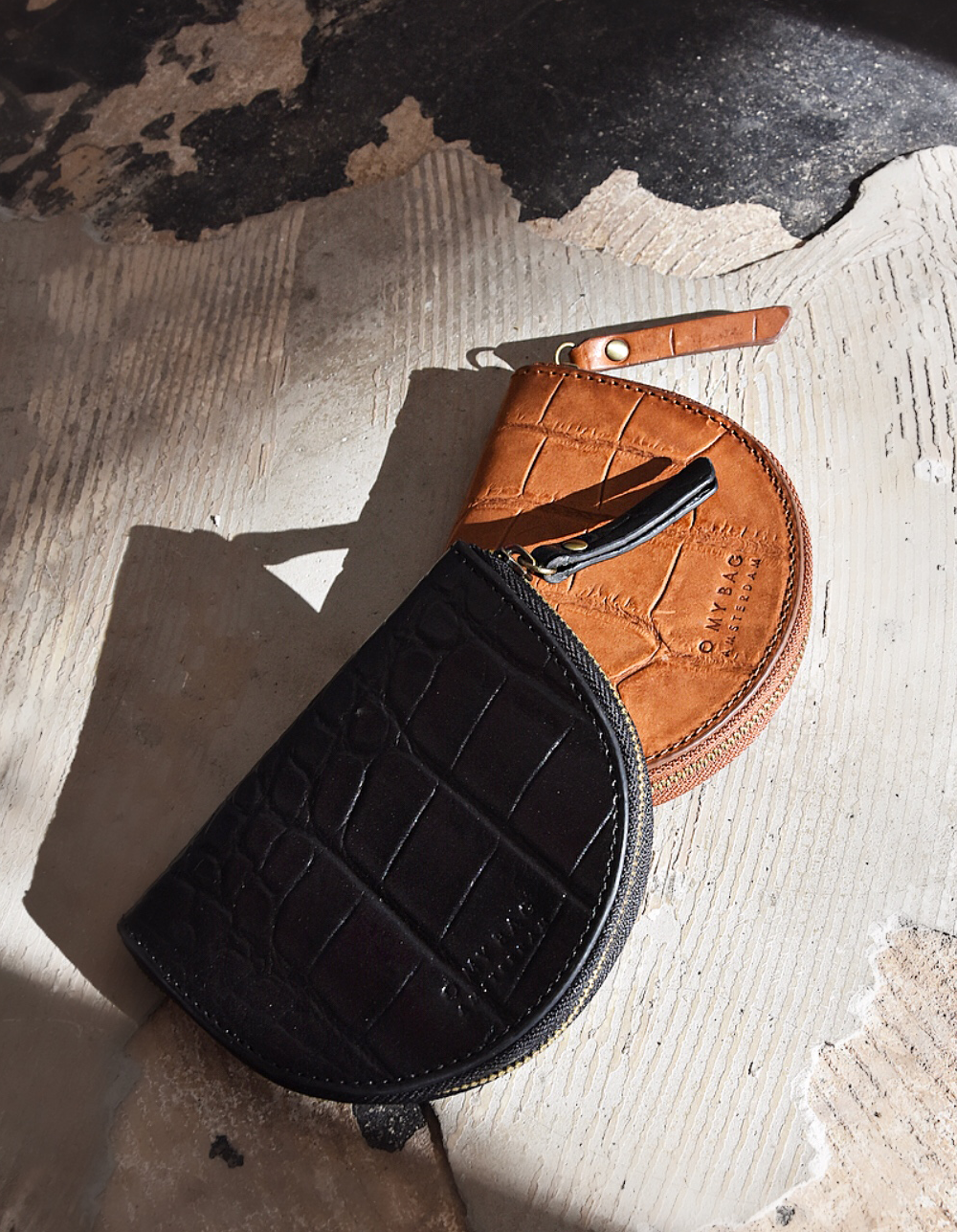 Laura Purse Black Classic Croco Leather. Round mood shape coin purse unisex wallet. Lifestyle image.