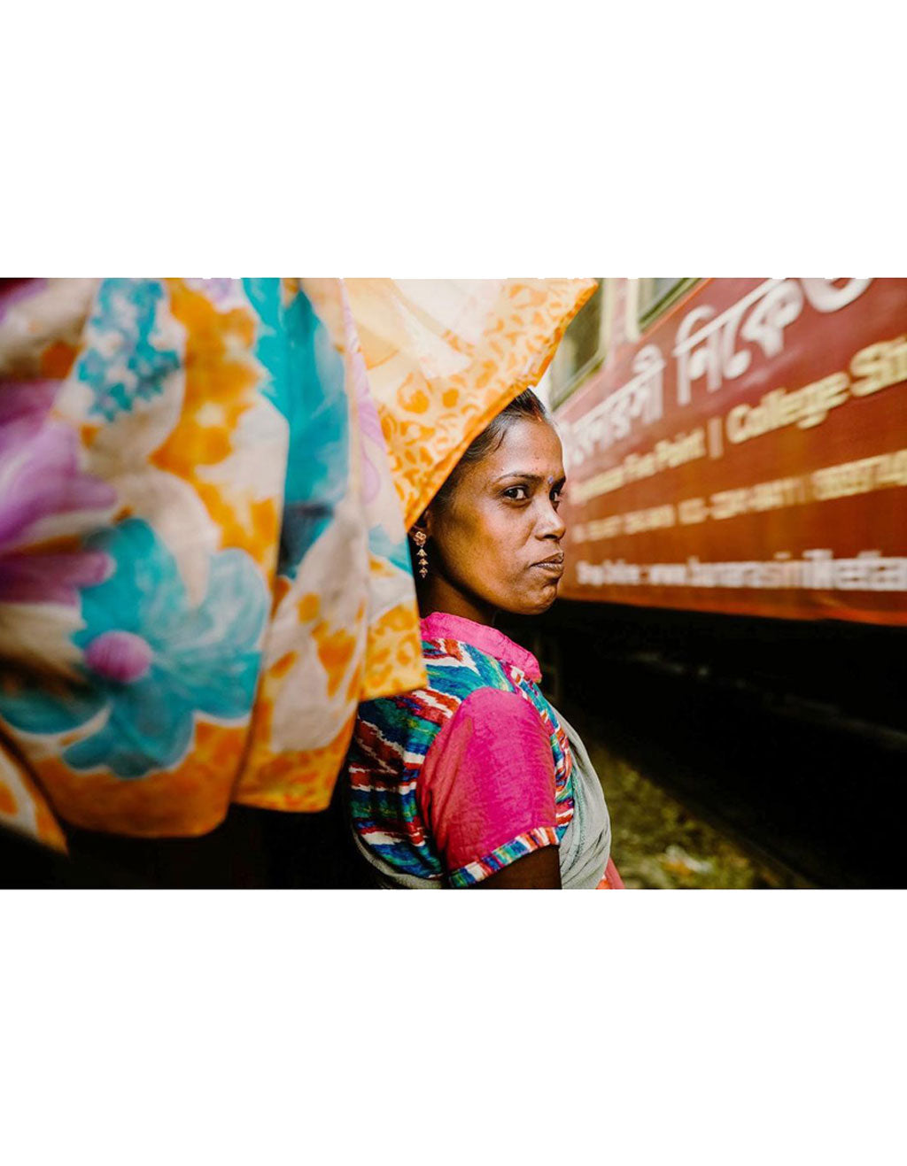 A woman in colorful dress waits for the train in Kolkata India.