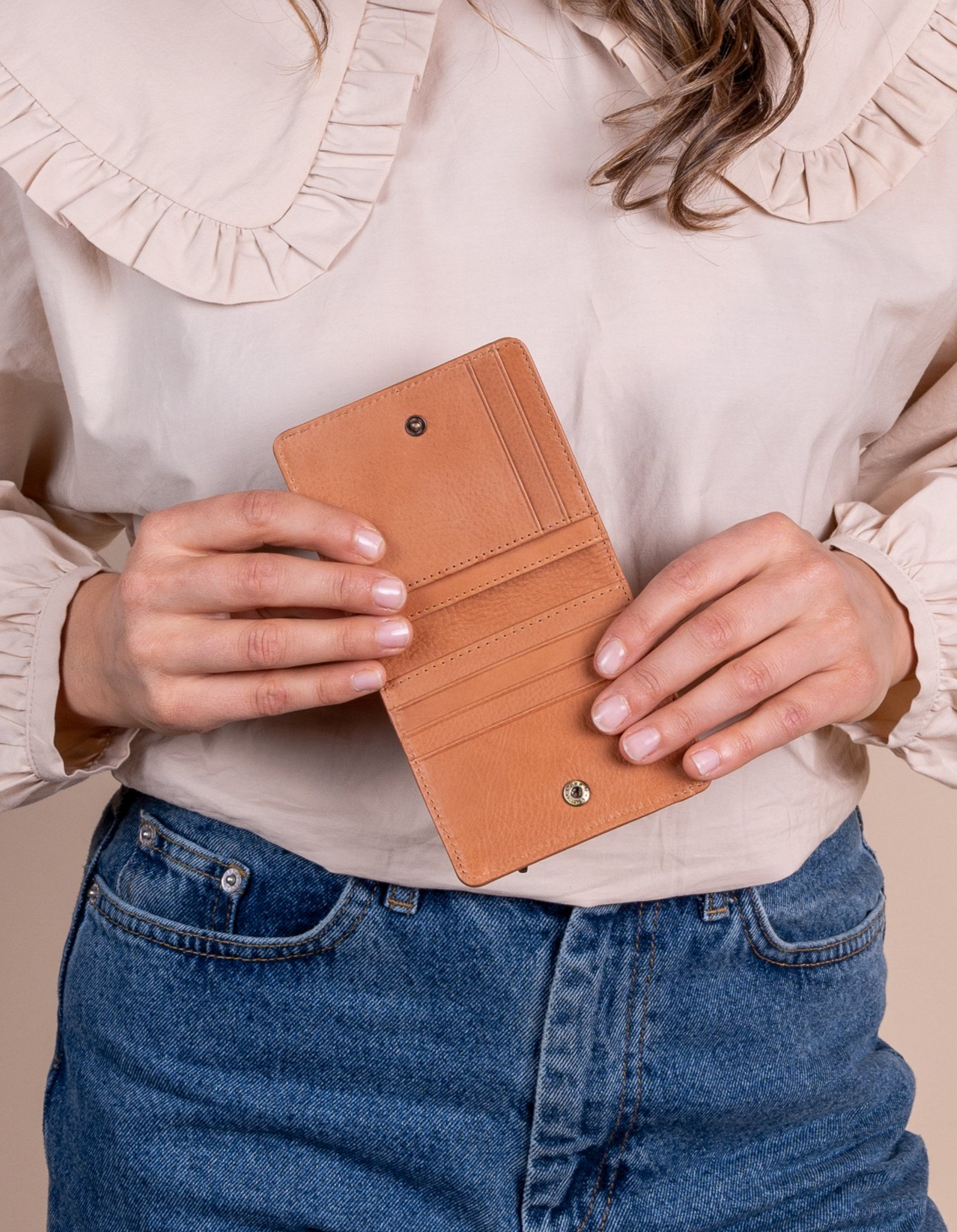 Alex fold over wallet in wild oak soft grain leather. Model product image.