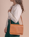 Model with Audrey in cognac apple leather and plain strap.