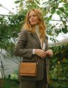 Audrey Mini Apple Vegan Leather Cognac Rectangle Ladies Handbag, Model Lifestyle image.
