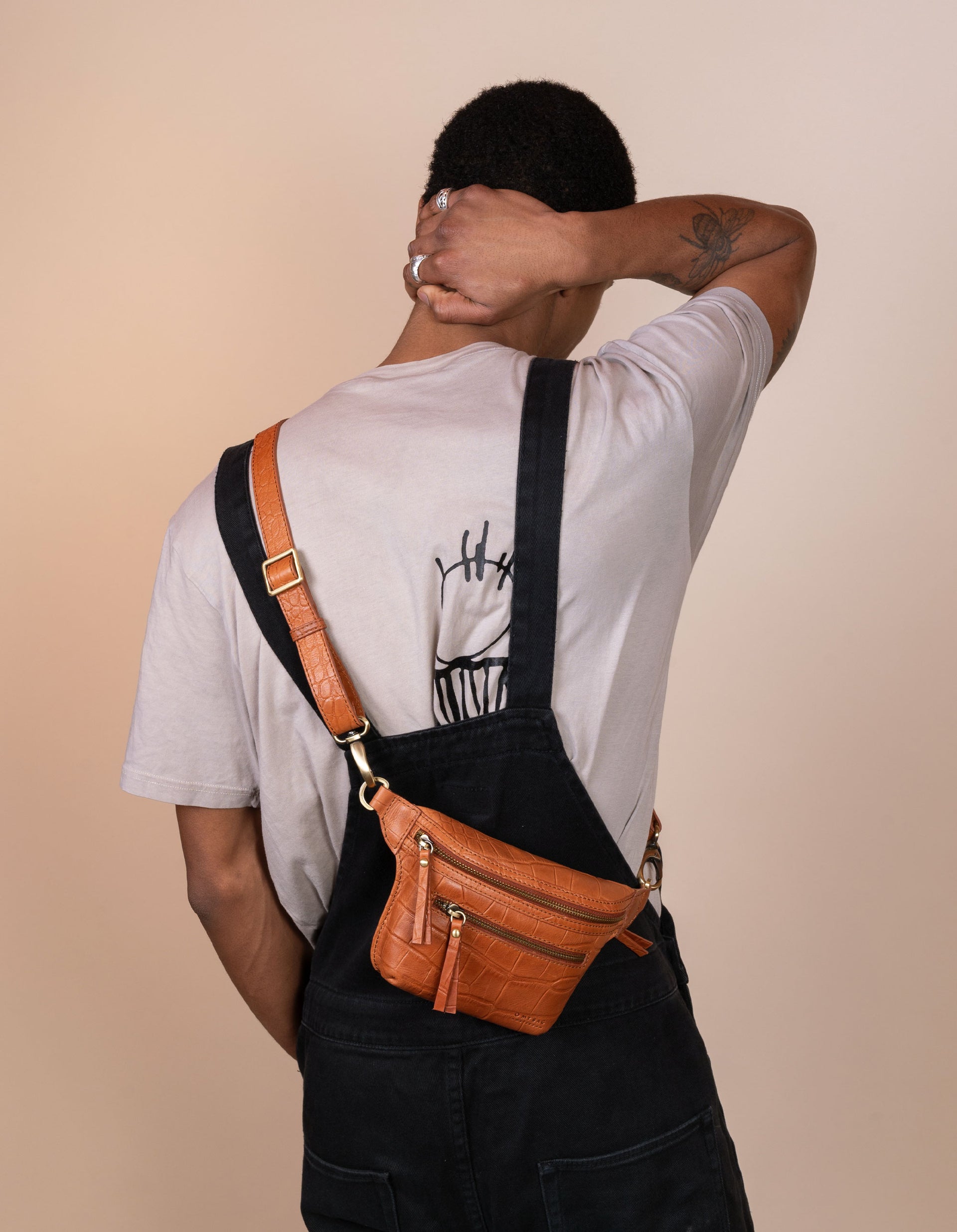 Wild Oak Croco Leather fanny pack. Square shape with an adjustable strap. Male product image. Back View.