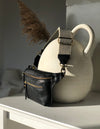 Black Leather womens fanny pack. Square shape with an adjustable strap. Lifestyle product image