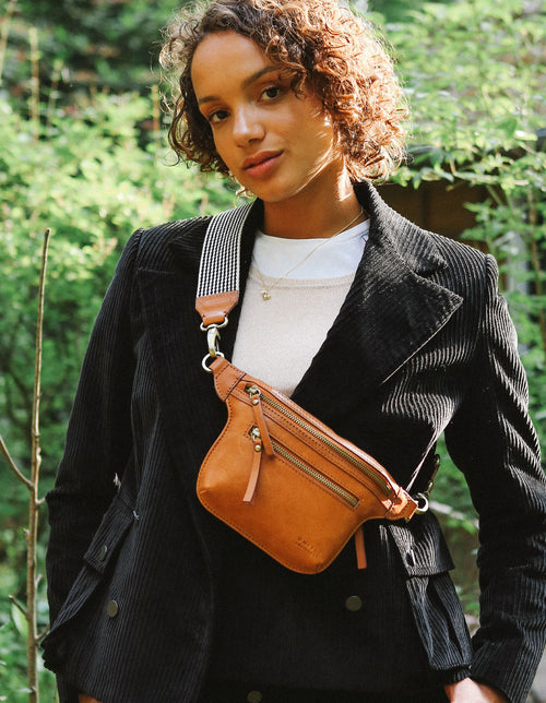 Cognac Leather womens fanny pack. Square shape with an adjustable strap. Lifestyle product image