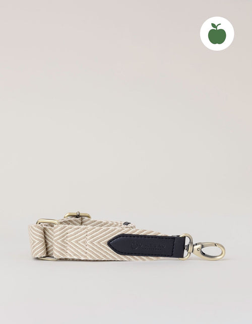 Herringbone webbing strap in Sand & Black Apple Leather details. Front product image.
