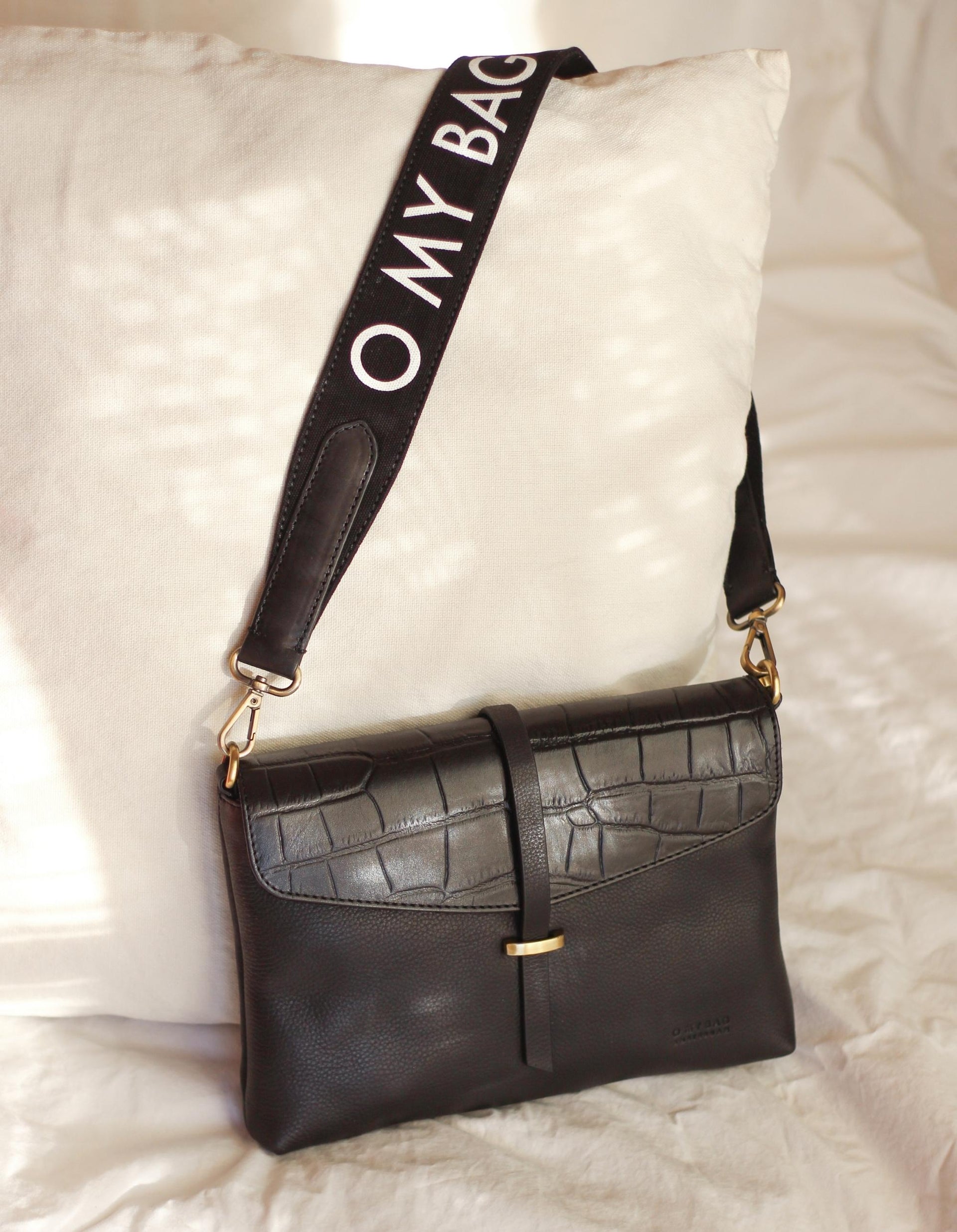 Canvas O My Bag Logo Strap in black. Lifestyle image, styled with Ella Midi Black Croco