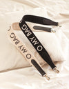 White canvas cotton handbag strap with black leather details and logo print. lifestyle image.