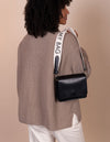 Organic cotton white logo strap with black leather details - model image from the back