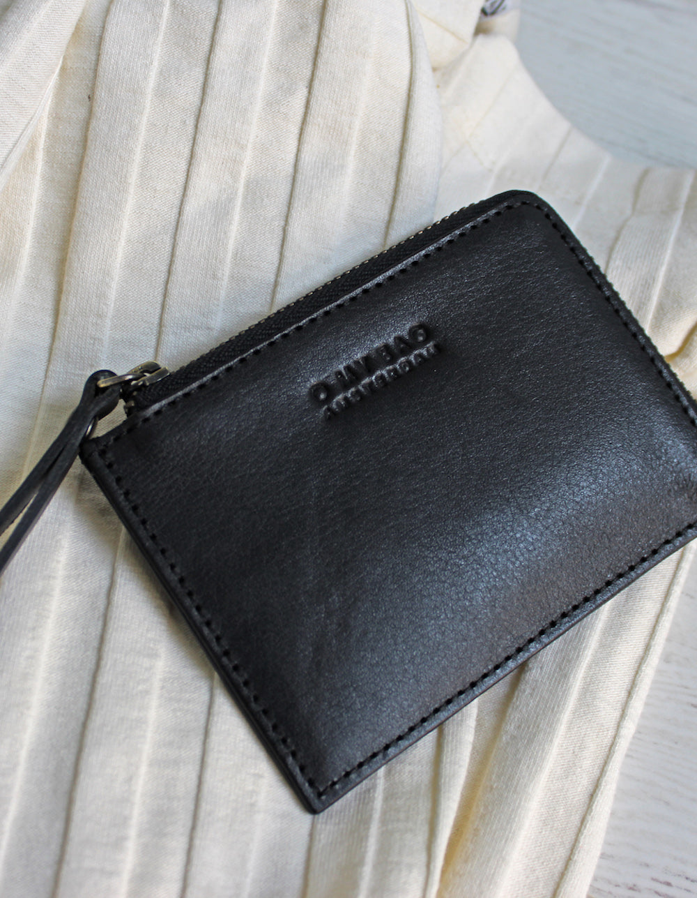 Small Black Classic Leather coin purse. Square shape. Lifestyle image