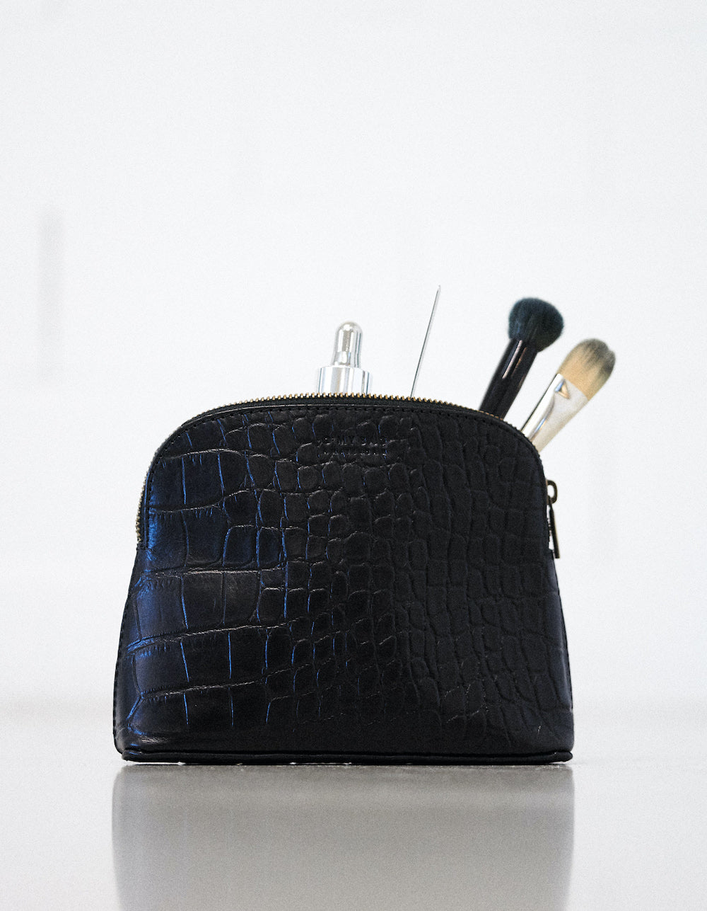 Cosmetic bag. Rectangle shape, black croco leather. Front picture with brushes