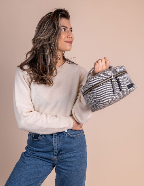 Model holding the Elise makeup bag. Product image.