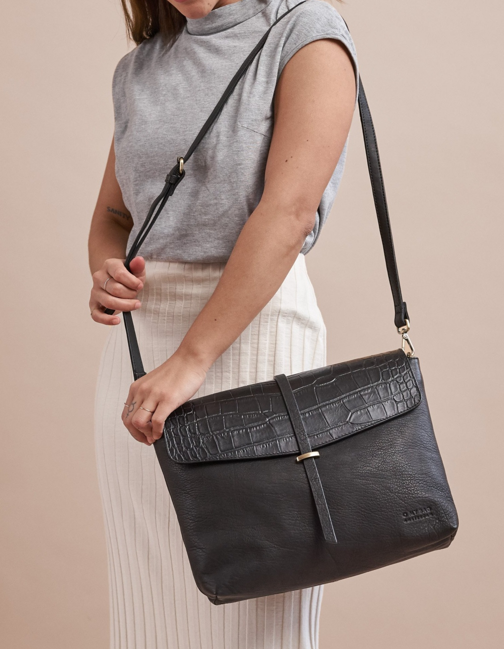 Black Classic Croco leather womens handbag. Square shape with an adjustable strap. Model product image.