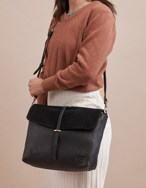 Black Soft Grain & Suede leather womens handbag. Square shape with an adjustable strap. Model product image.
