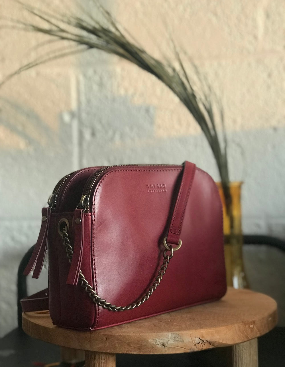 Ruby Leather womens handbag. Square shape with an adjustable leather & chain strap. Lifestyle image.