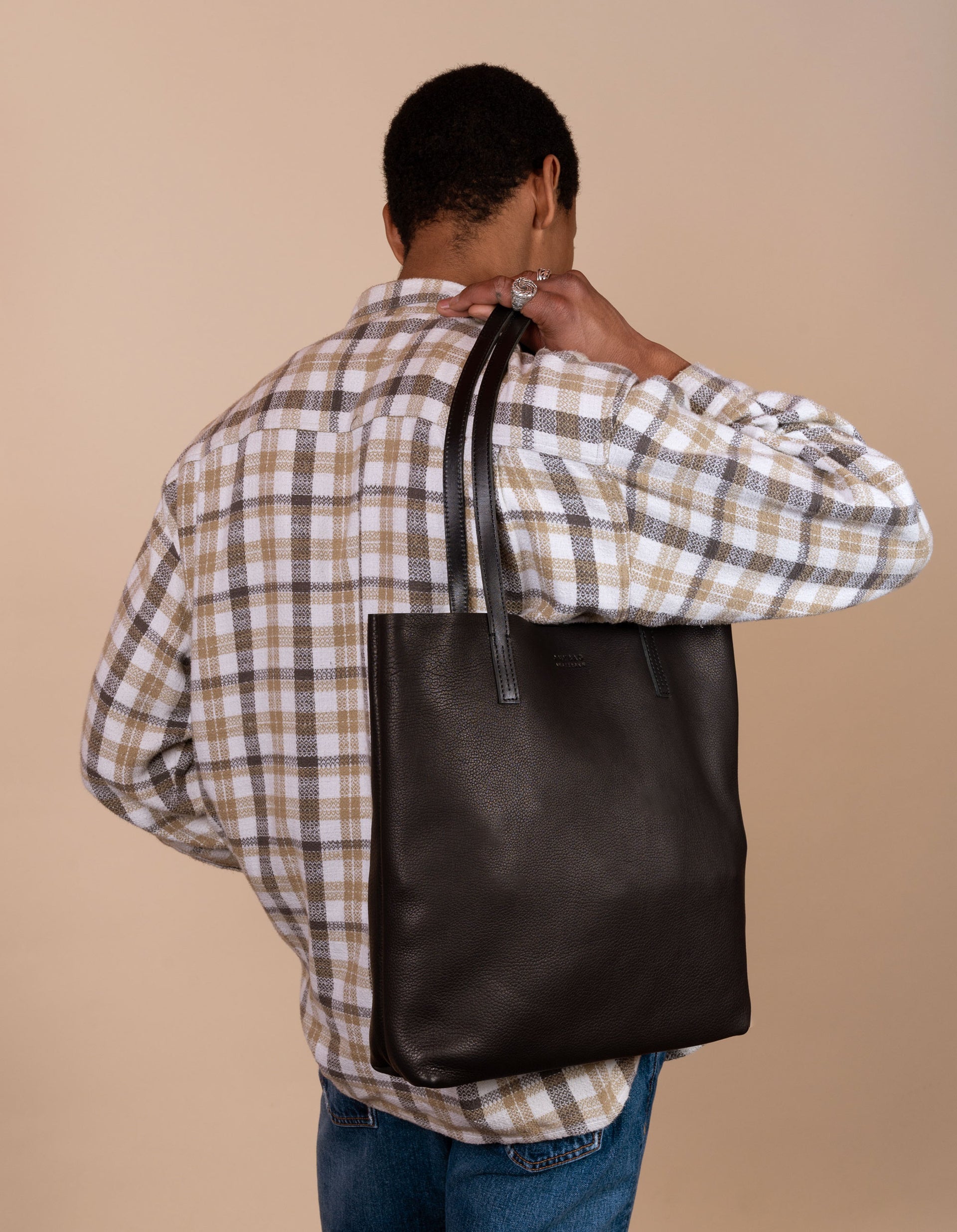Georgia tote in black soft grain leather - male model product image - image from the back