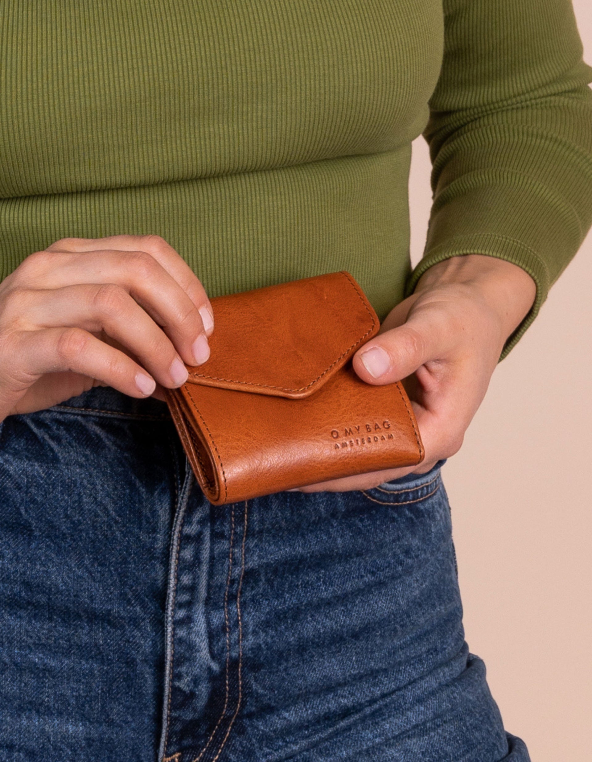 Model holding Georgie's wallet in cognac leather.