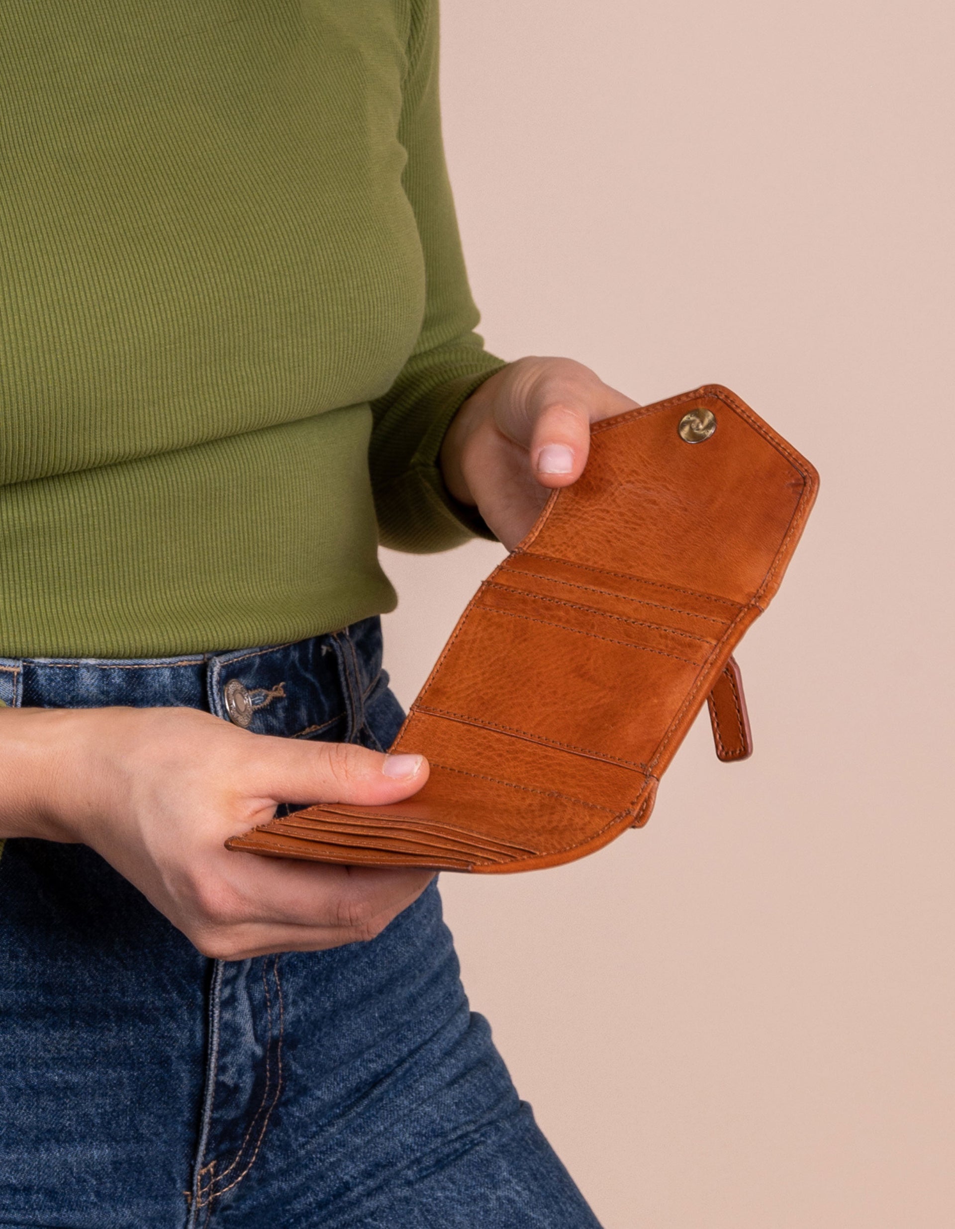 Model holding Georgie's wallet in cognac leather. Inside view.