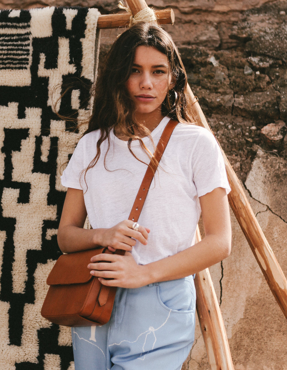 Cognac Leather womens handbag. Square shape with an adjustable strap. Lifestyle product image.