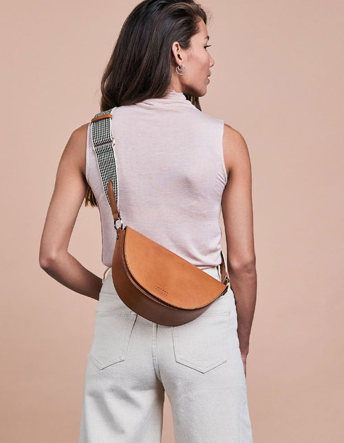 Laura Bag Cognac Classic Leather. Round mood shape crossbody bag for women. Model image.