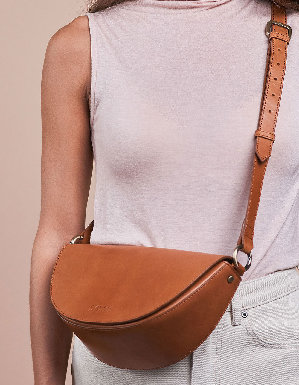 Laura Bag Cognac Classic Leather. Round mood shape crossbody bag for women. Model image.