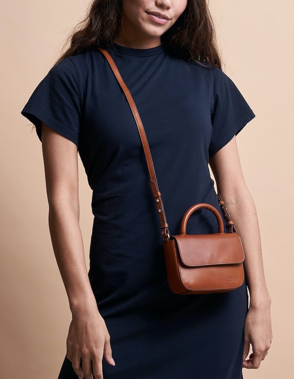 Nano Bag Cognac Classic Leather. Small clutch handbag, party bag. Model image.